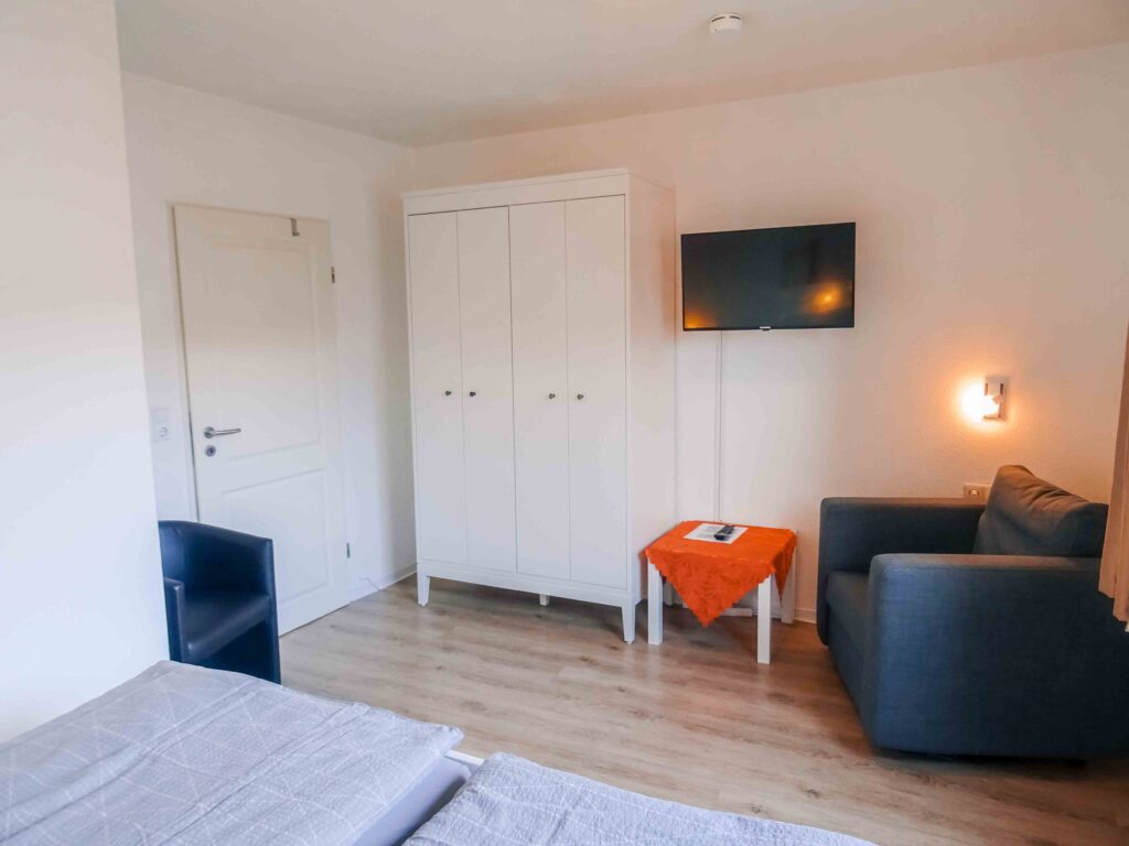 Schlafzimmer mit Kleiderschrank und Sessel